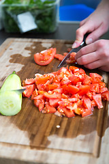 Image showing a woman cuts vegetables for a salad