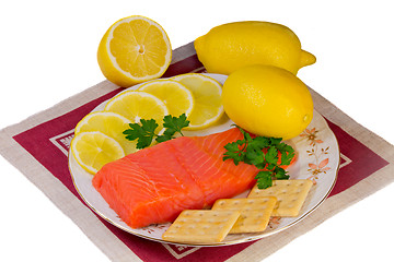 Image showing Salmon fillet and lemons on a platter on a white background.