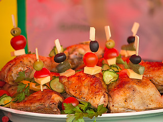 Image showing Fried chicken legs on a plate decorated with vegetables and herb