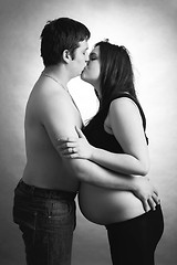 Image showing loving happy couple, husband kissing pregnant woman