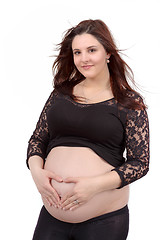 Image showing beautiful pregnant woman tenderly holding her tummy isolated on white background