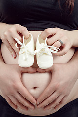 Image showing pregnant woman with a child's shoe