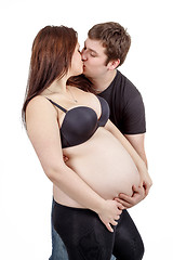 Image showing loving happy couple, husband kissing pregnant woman