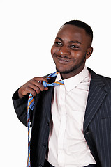 Image showing Black man taking off tie.