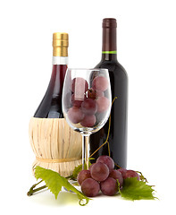 Image showing wine glass full with grapes and two wine bottles 