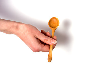 Image showing Hand holding wooden spoon isolated on white background