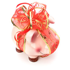 Image showing Christmas deposit concept. Piggy bank with festive bow isolated 