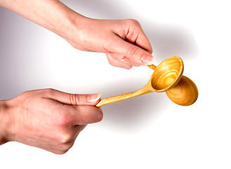 Image showing Hand holding wooden spoon isolated on white background