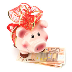 Image showing Christmas deposit concept. Piggy bank with festive bow isolated 