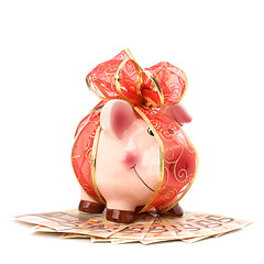 Image showing Christmas deposit concept. Piggy bank with festive bow isolated 