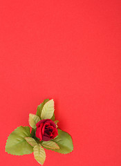 Image showing Red background with floral decor. Flowers are artificial. 