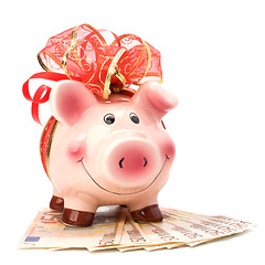 Image showing Christmas deposit concept. Piggy bank with festive bow isolated 