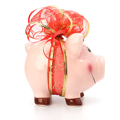 Image showing Christmas deposit concept. Piggy bank with festive bow isolated 