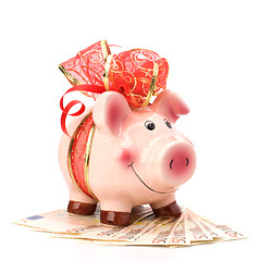 Image showing Christmas deposit concept. Piggy bank with festive bow isolated 