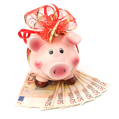 Image showing Christmas deposit concept. Piggy bank with festive bow isolated 