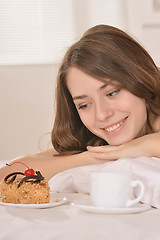 Image showing woman lying in bed with cake and juice