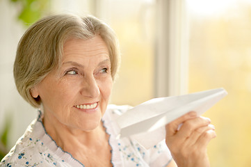 Image showing Senior woman with paper plane