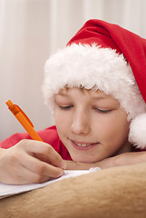 Image showing Boy in santa hat writing