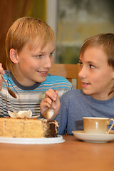 Image showing Two little brothers eat cake