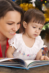 Image showing Cute mother decided to read to her children