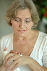Image showing Senior woman applying cream