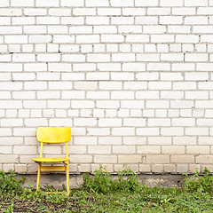 Image showing brick wall and yellow seat