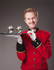 Image showing Smiling Waiter in red uniform