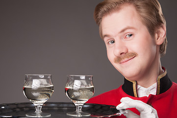 Image showing Smiling Waiter in red uniform