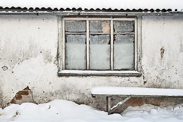 Image showing wall with window background, bench near the wall, slate roof and