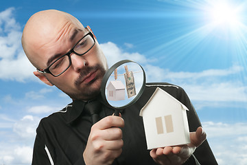 Image showing Man with a magnifying glass and paper house