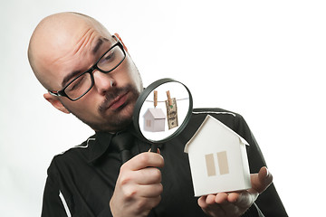 Image showing Man with a magnifying glass and paper house
