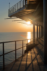 Image showing Sunset pier along coast