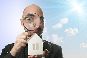 Image showing Man with a magnifying glass and paper house