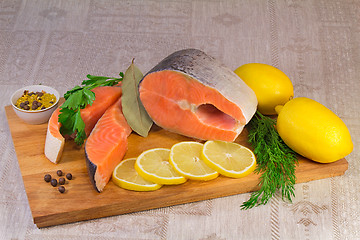 Image showing Fish salmon, lemon and greens placed on the table.