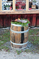 Image showing Wooden barrel with flaming torches