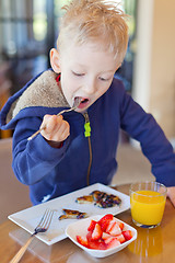 Image showing child eating breakfast