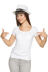 Image showing Smiling woman pointing at blank white t-shirt
