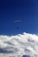 Image showing Silhouette of paraglider and blue sky with clouds