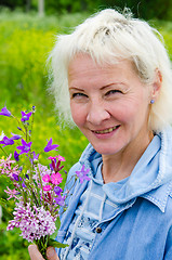 Image showing Portrait of a middle-aged woman with a bouquet of wild flowers