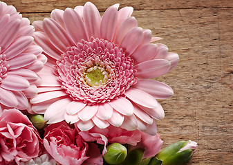 Image showing Pink flowers closeup on a wood background