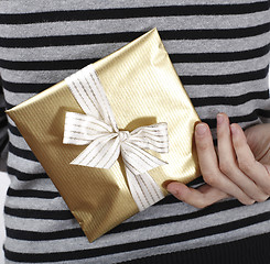 Image showing Young woman holding a present