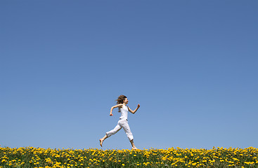 Image showing Happy girl running in dandelion field