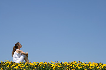 Image showing Girl sitting in dandelion field