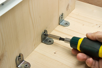 Image showing Screwing a screw at manufacturing of wooden furniture