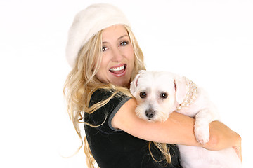 Image showing Smiling female holding a dog in her arms