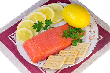 Image showing Salmon fillet and lemons on a platter on a white background.