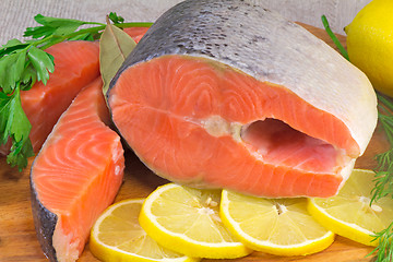 Image showing Fish salmon, lemon and greens placed on the table.