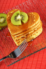 Image showing Stack of heart-shaped pancakes with syrup and kiwi fruit