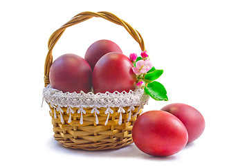 Image showing Red Easter eggs in a basket on a white background.