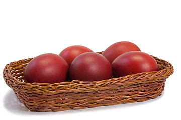 Image showing Red Easter eggs in a basket on a white background.